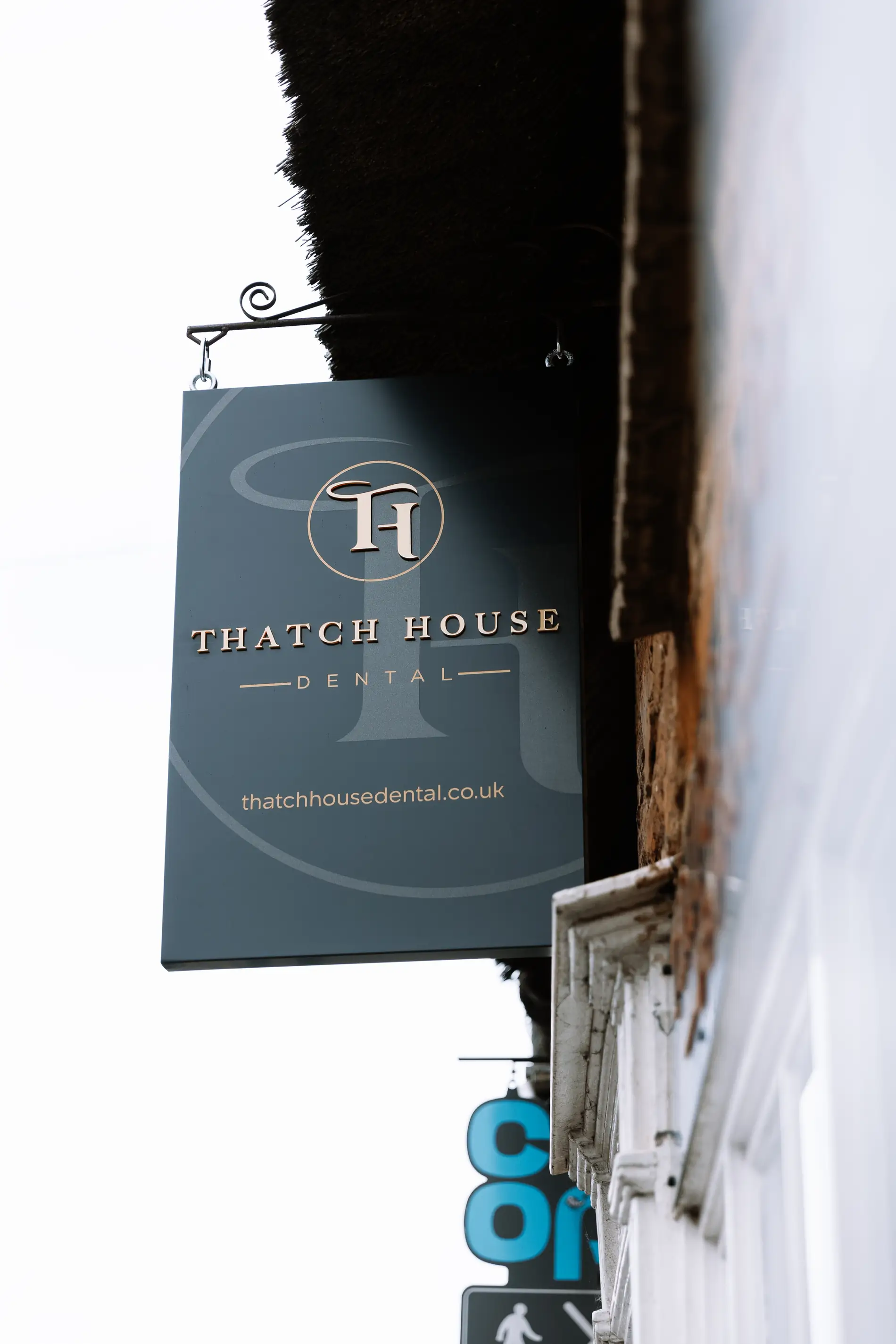 Thatch house dental projecting hanging sign bracket gold lettering Mindlabs Media